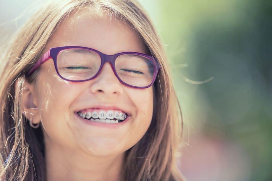 young girl with purple glasses and braces, smiling