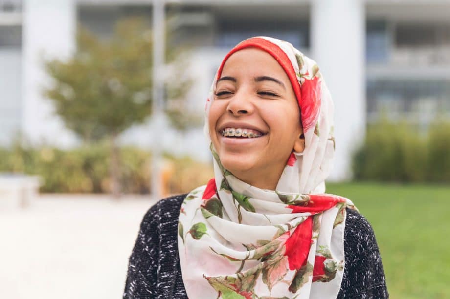 young girl with head scarf and braces, smiling